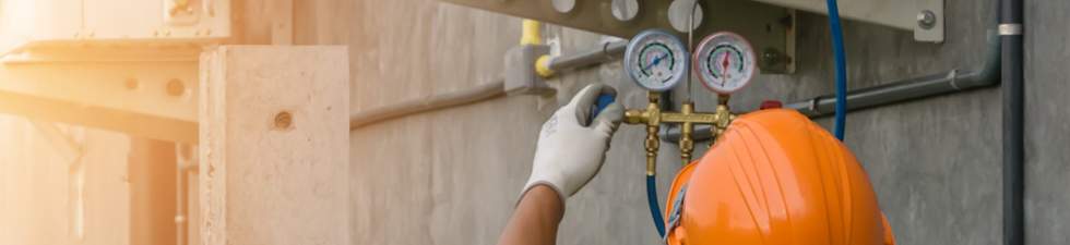 Tech Service Advisors Auto mechanic uses a pressure gauge on the air compressor